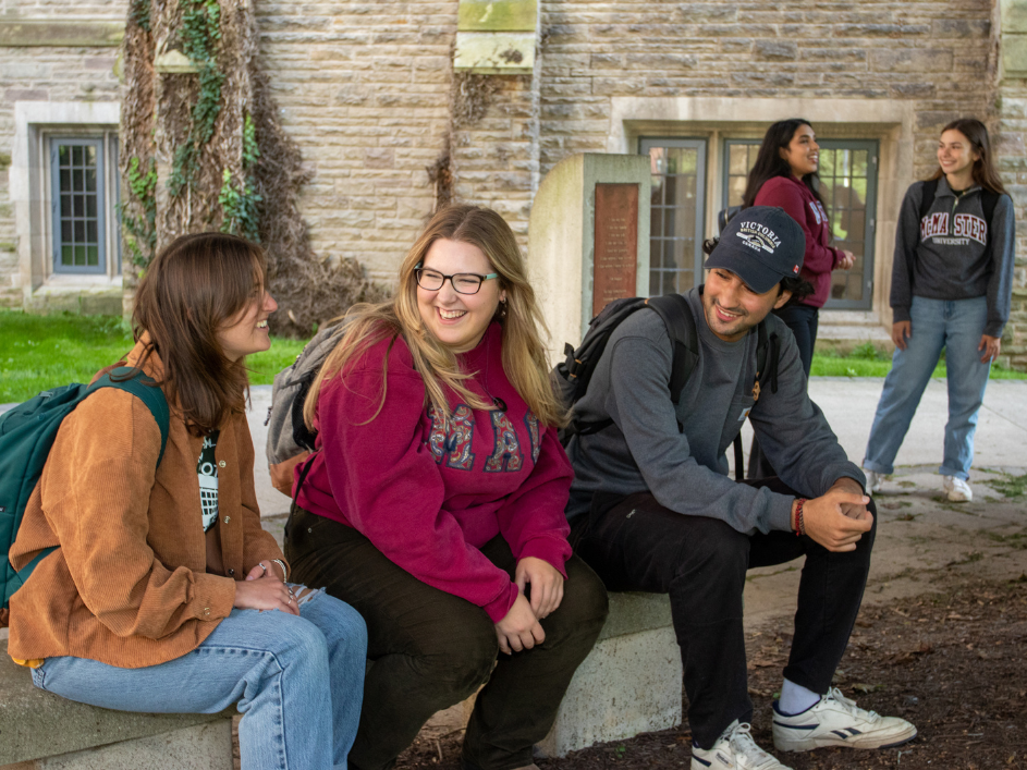 Undergraduate-Current-Student-Resources. Several students gathered on an outdoor bench, engaging in scholarly discourse amidst the backdrop of McMaster University.