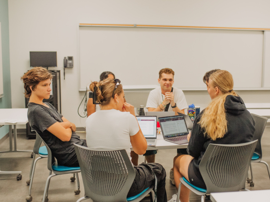 A seated group of students conversing in a circle.