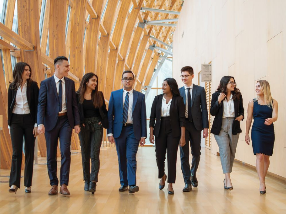 Undergraduate-Minors-and-Professional-Designations. A team of business professionals, elegantly attired, walking confidently through a corporate corridor.